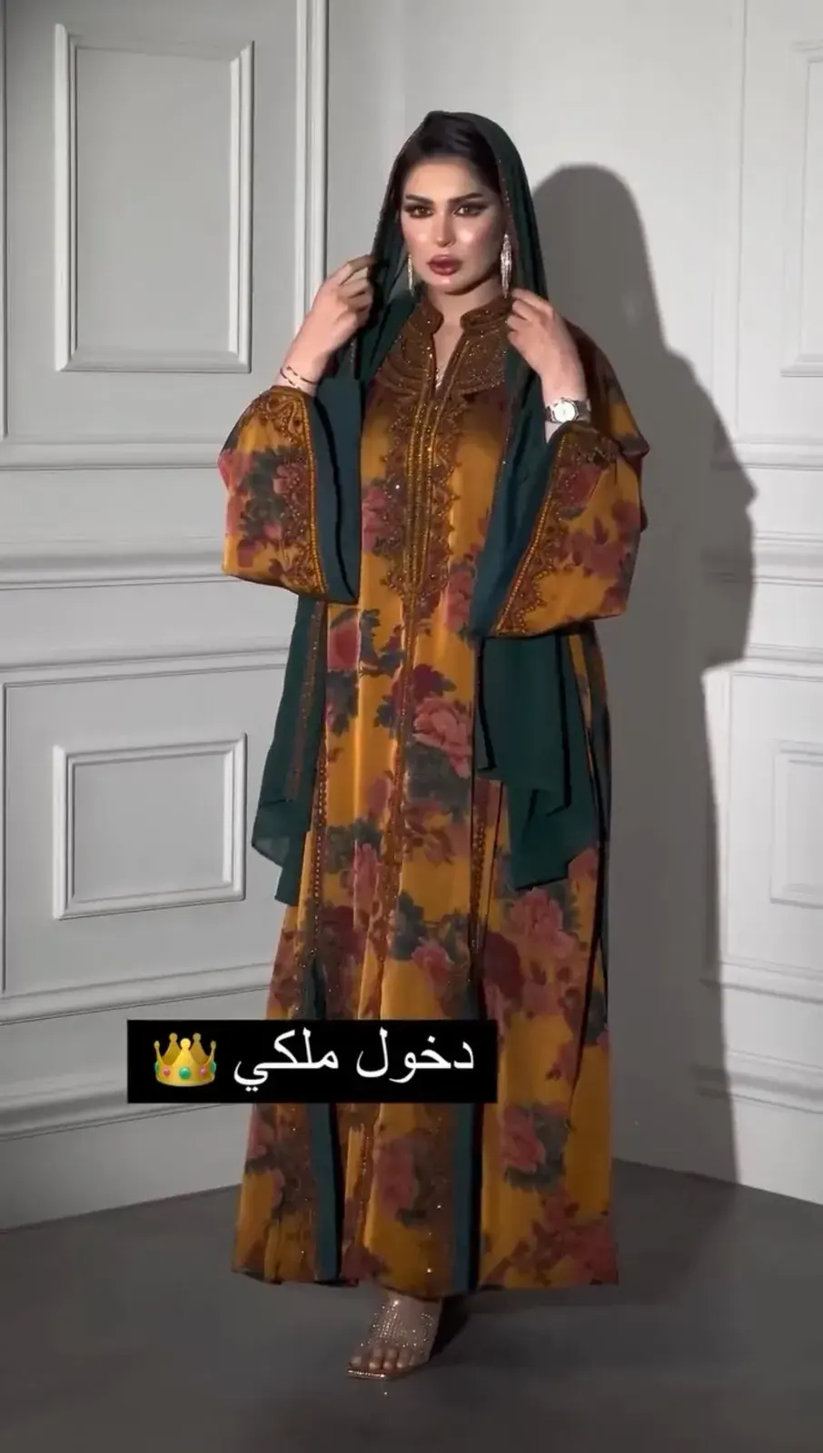 Model in a saffron floral-print kaftan with an emerald shawl over the shoulders