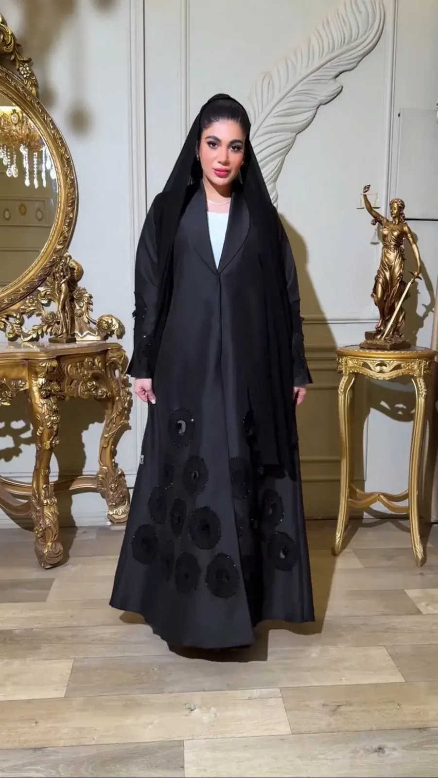 Model in a black abaya with black rosette appliqué and a matching shayla