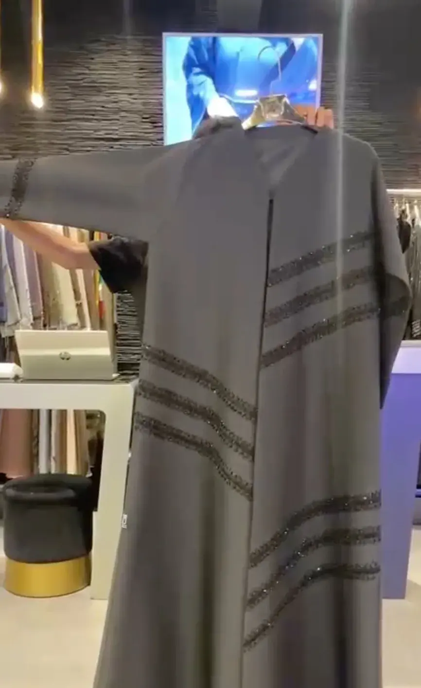 Grey abaya with diagonal crystal stripes, shown on a hanger