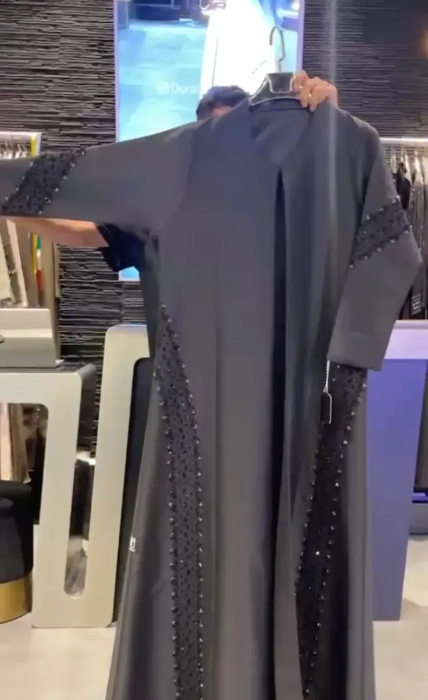 Grey abaya with beaded front panels and sleeves, shown on a hanger