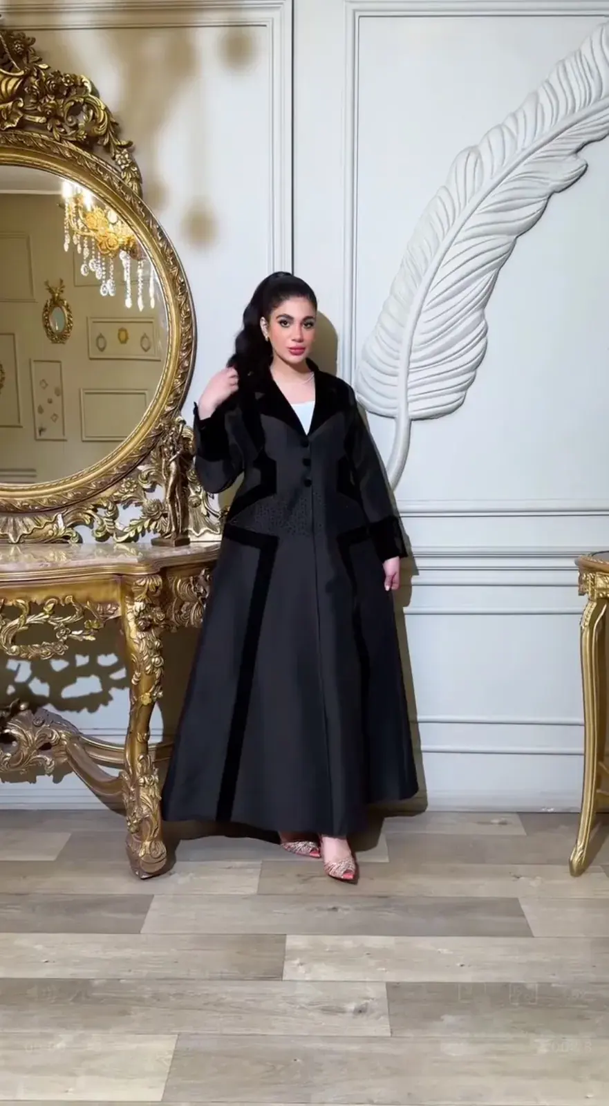 Model in a black abaya with wide velvet trim at the front and hem