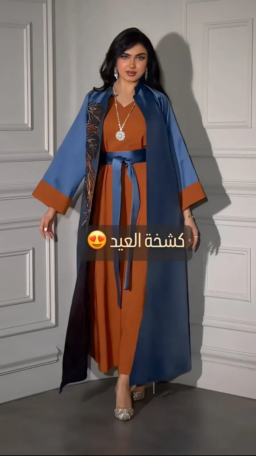 Model in an indigo satin robe over a rust dress with an indigo sash