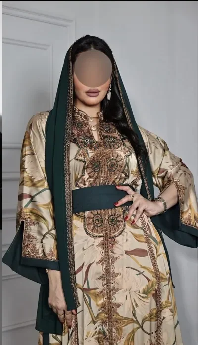 Model in a sand botanical-print kaftan with a forest-green hood and sash
