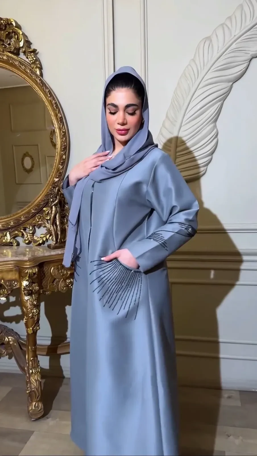 Model in a steel-blue satin abaya with a pleated fan detail and matching shayla