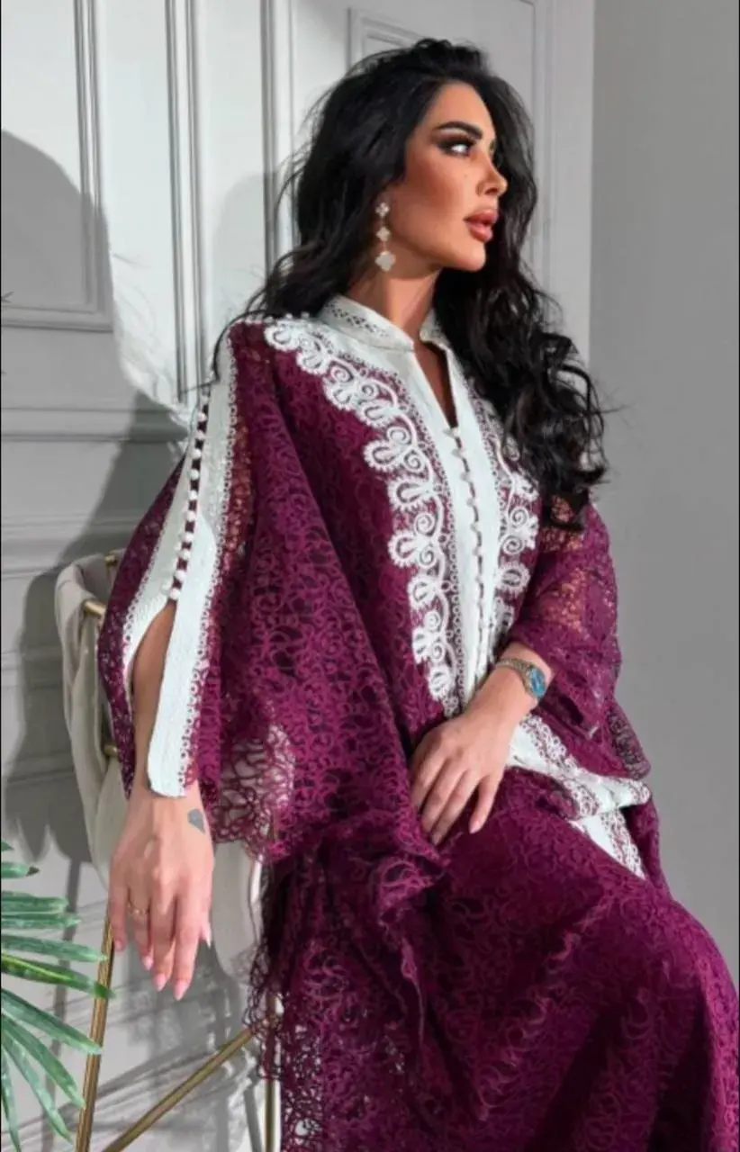 Model seated in a plum lace bisht kaftan with ivory embroidered trim and split sleeves