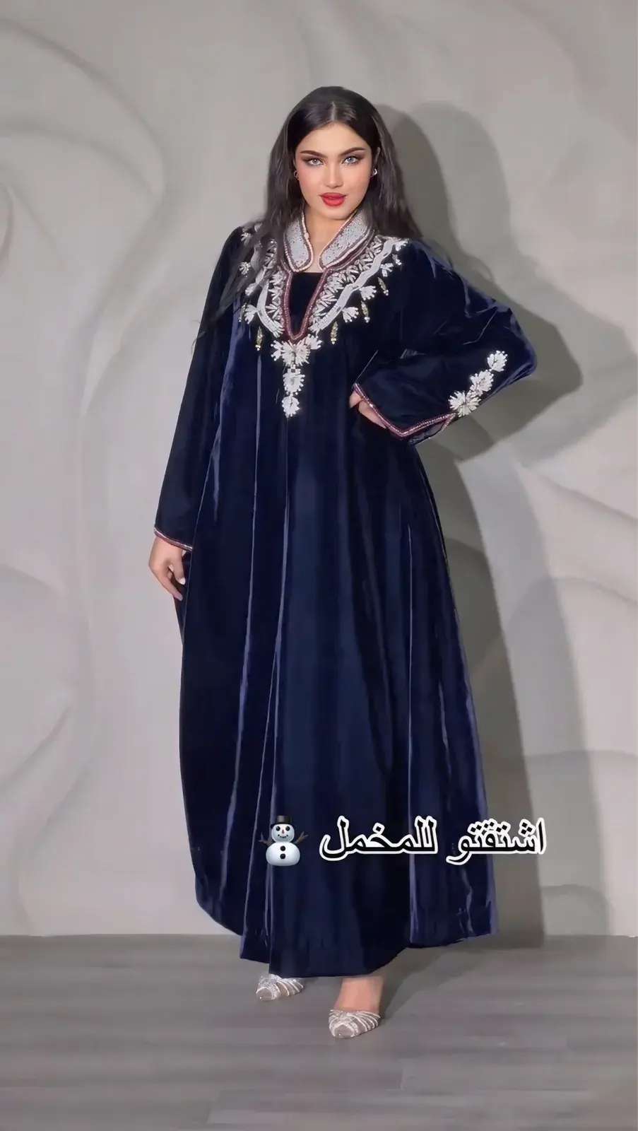 Model in a midnight-navy velvet jalabiya with silver floral embroidery